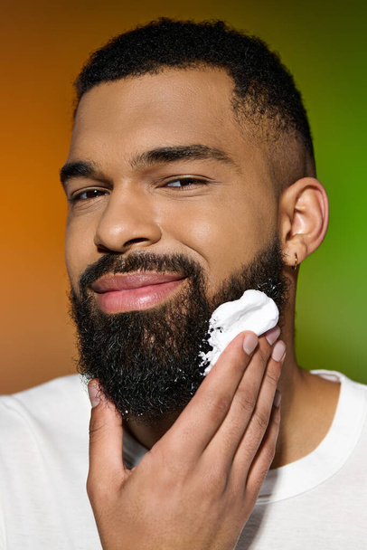 Αφροαμερικανός όμορφος άντρας που χρησιμοποιεί κρέμα ξυρίσματος. - Φωτογραφία, εικόνα