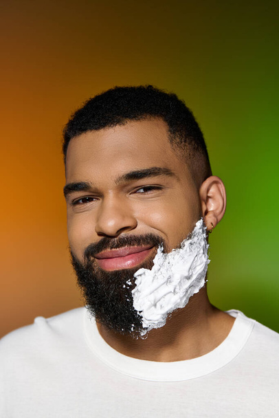 Africano americano jolly hombre usando afeitar crema. - Foto, imagen
