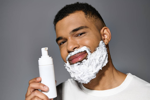 Hombre guapo con barba sostiene la botella de afeitar. - Foto, imagen