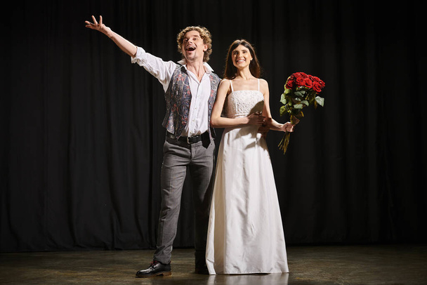 Чоловік і жінка витончено стоять на театральній сцені під час репетицій. - Фото, зображення