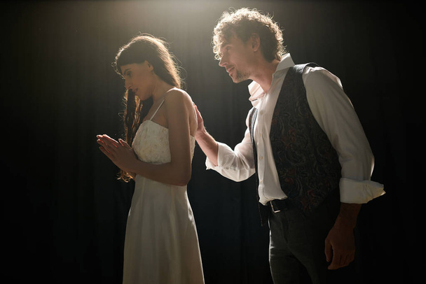 Ein gutaussehender Mann und eine schöne Frau stehen Seite an Seite auf der Bühne während der Theaterproben. - Foto, Bild