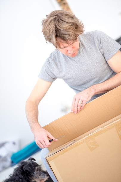 Man unpacking a cardboard carton - Photo, Image