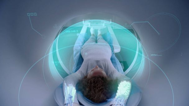 Frau unterzieht sich Kernspintomographie oder CT, liegt auf dem Bett in der Maschine. Visuelle Effekte beim Scannen von Gehirn und Körper weiblicher Patienten. High-Tech-Geräte im modernen medizinischen Labor mit Augmented-Reality-Technologien. - Foto, Bild