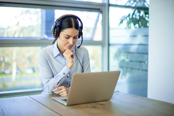 Koncentrált üzleti nő helpdesk üzemeltető laptopot használ a modern irodában - Fotó, kép