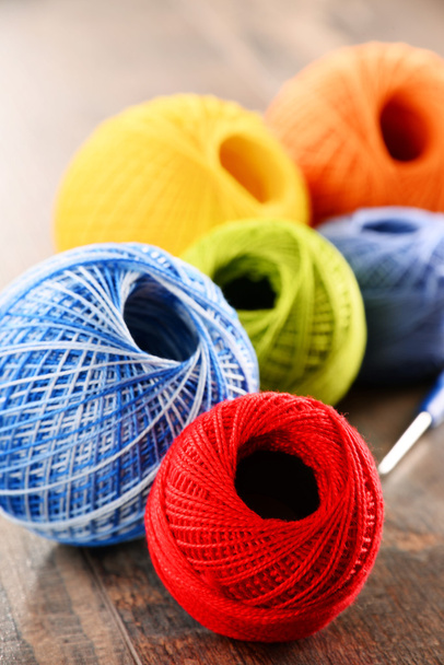 Colorful yarn for crocheting and hook on wooden table - Fotoğraf, Görsel