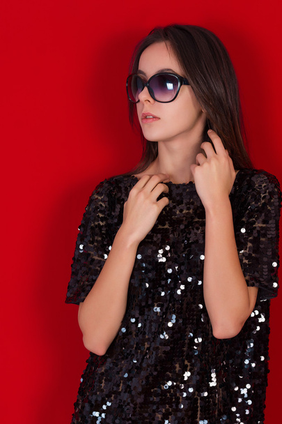 Beautiful brunette girl in a black dress and sunglasses. Brunette with long black hair - Zdjęcie, obraz