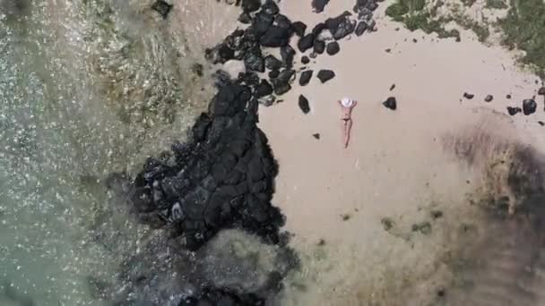 Повітряний відступ: жінка в чорному бікіні і білий капелюх відпочиває на пляжі - 4K Drone View of Exotic Tropical Summer Escape - Кадри, відео