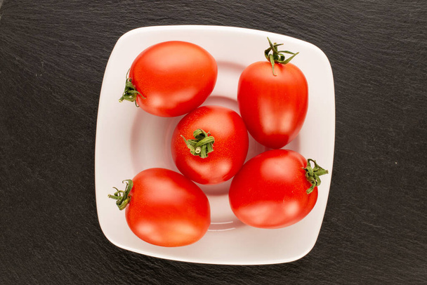 Useat cocktail tomaatit valkoinen keraaminen levy liuskekivi, makro, ylhäältä. - Valokuva, kuva