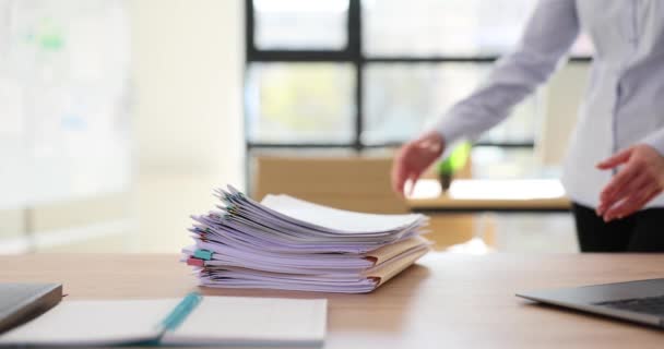 Женщина-работница уносит стопку папки с заданиями со стола в офисе. Рабочие материалы, направленные на повышение производительности компании - Кадры, видео