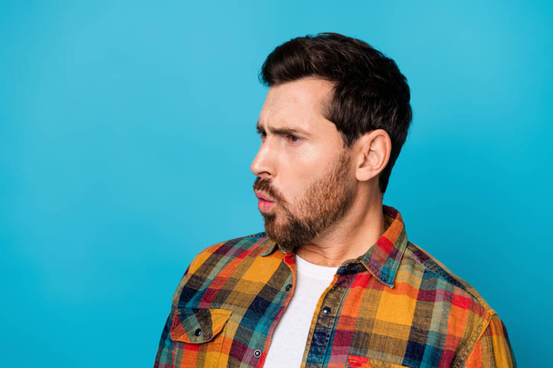Portrait of astonished guy with stubble wear checkered shirt look at profitable proposition empty space isolated on blue color background. - Foto, afbeelding