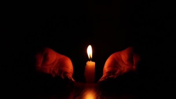 Γυναικεία χέρια κοντά σε μια φλόγα κεριού στο σκοτάδι, την πίστη και τη θρησκεία, προσεύχονται - Πλάνα, βίντεο
