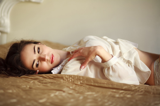Sensual young woman thoughtfully lying on the bed at home - Foto, Bild