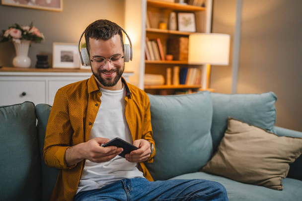 Один чоловік з навушниками вдома слухати музику онлайн щаслива посмішка - Фото, зображення
