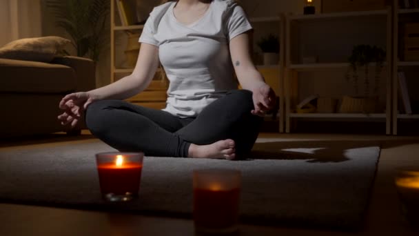 Onherkenbare vrouw in meditatiepositie thuis. - Video
