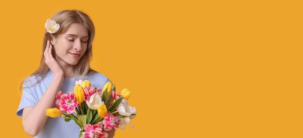 Pretty young woman with bouquet of beautiful tulips on yellow background with space for text - Photo, Image