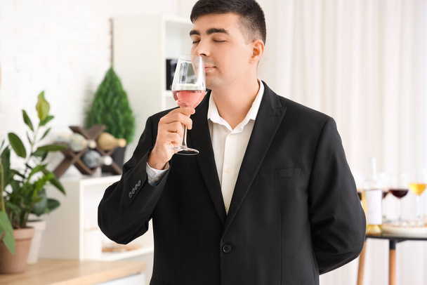 Sommelier joven con copa de vino rosa en la cocina - Foto, imagen