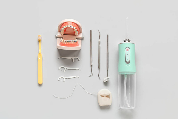 Conjunto para higiene dentária com irrigador oral e ferramentas odontológicas em fundo claro - Foto, Imagem