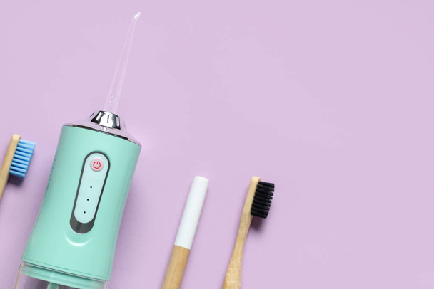 Irrigatore orale e spazzolini da denti su sfondo di colore - Foto, immagini