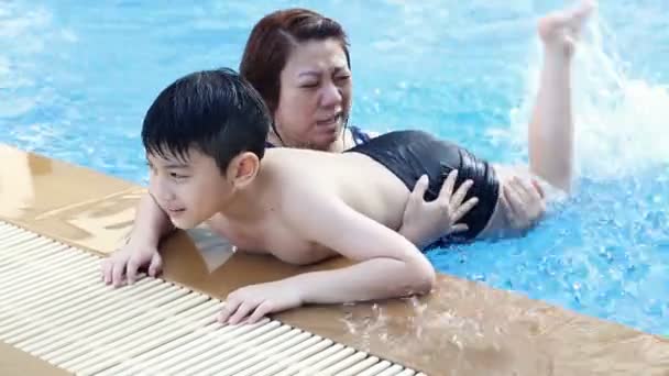 Mały chłopiec azjatyckich nauki jak basen z matką - Materiał filmowy, wideo