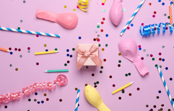 Cajas de regalo, confeti, velas y globos sobre fondo pastel. Cumpleaños, concepto de fiesta. Vista superior - Foto, imagen