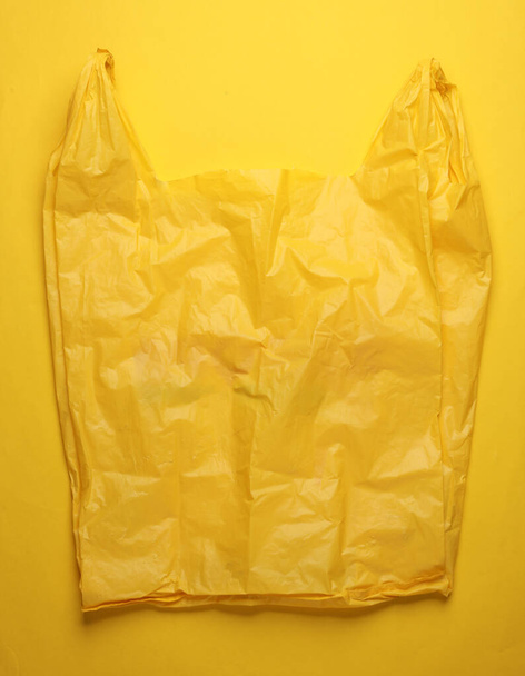 Желтая целлофановая сумка на желтом фоне - Фото, изображение