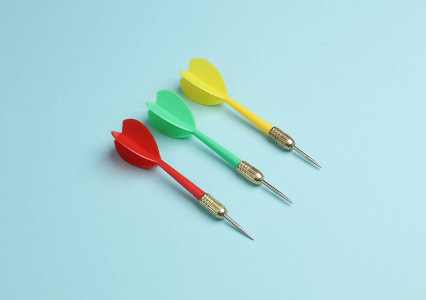 Yellow, green and red darts on blue background. - Photo, Image