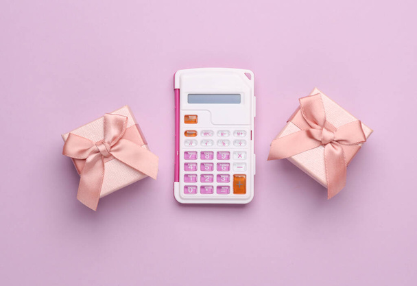 Cajas de regalo y calculadora sobre fondo rosa. Vista superior - Foto, imagen