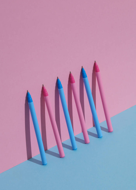 Пластиковые розовые и голубые ручки на сине-розовом пастельном фоне. Бизнес, концепция образования. Креативная планировка, минимализм - Фото, изображение