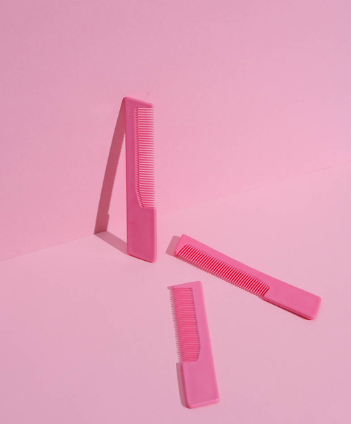 Peines de plástico sobre fondo pastel rosa. Concepto de belleza. Diseño creativo, minimalismo - Foto, Imagen