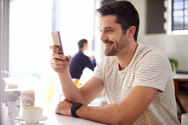 Happy man, relaks w kawiarni ze smartfonem i przewiń online dla mediów społecznościowych, technologii i komunikacji. Czat, czytanie na aplikacji lub ebook z przerwą w kawiarni, kontakt i korzystanie z telefonu z sieci. - Zdjęcie, obraz