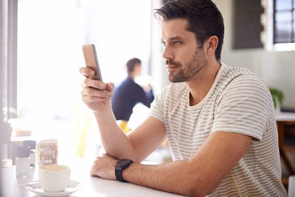 Man in cafe, smartphone en scroll op sociale media, lezen op mobiele app of ebook met communicatie en contact. Chat, e-mail of sms met tech, zoek internet en online in de coffeeshop. - Foto, afbeelding