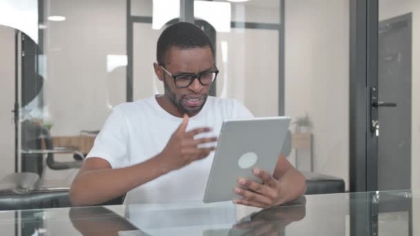 Młody Afrykanin robi czat wideo na tablecie w biurze - Materiał filmowy, wideo