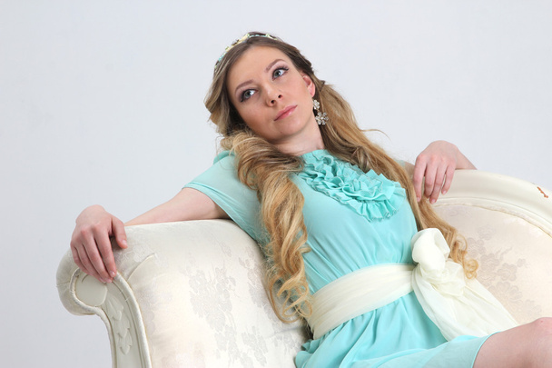 Pretty young woman leaned back on white sofa - Foto, imagen