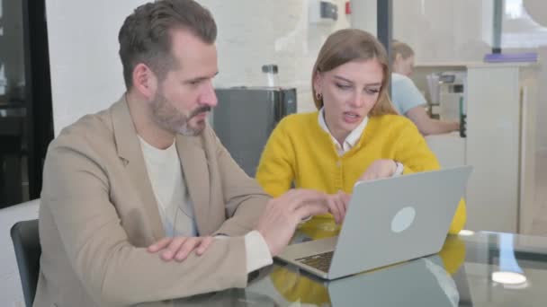 Молодые люди обсуждают работу на ноутбуке - Кадры, видео