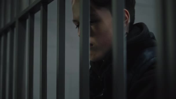 Hapishane müdürü demir parmaklıkların arkasında duran genç mahkumun kelepçelerini çıkarıyor. Ergen, ıslah evinde ya da gözaltı merkezinde hapis yatıyor. Hapishanede suçlu bir mahkum. Kapat.. - Video, Çekim