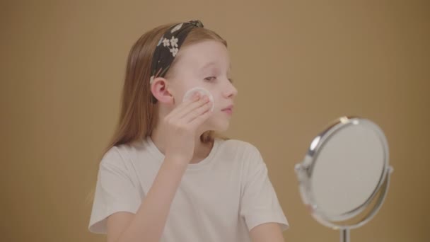 Roztomilé dospívající dívka pomocí obličeje sprej a bavlněné podložky očistit a hydratovat její obličej. Koncept krásy a péče o pleť produkty pro dospívající.  - Záběry, video