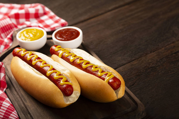 Hot dog z ketchupem i żółtą musztardą. - Zdjęcie, obraz