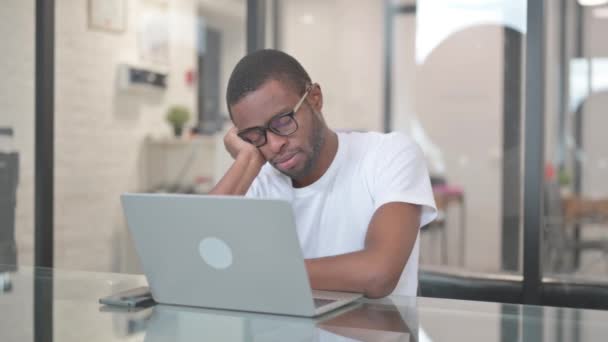 Сплячий афроамериканський чоловік сидить в офісі - Кадри, відео