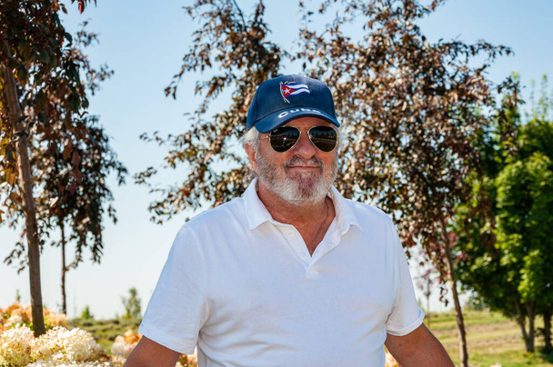 Yaz stili kıdemli İspanyol adam, bahar doğa parkında Küba şapkası takıyor.. - Fotoğraf, Görsel