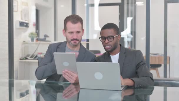 Twee mannen werken aan laptop en tablet - Video
