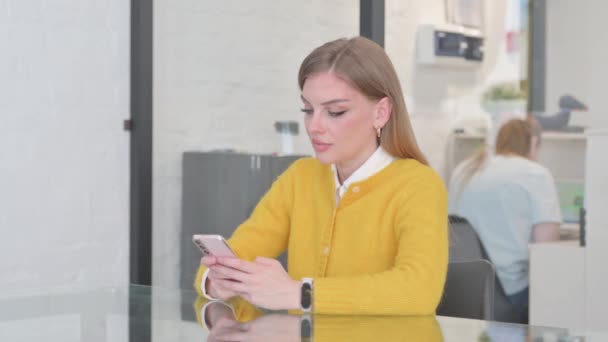 Blondi rento nainen kirjoittamalla viestin puhelimeen - Materiaali, video