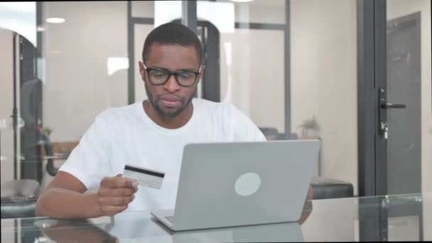 Joven hombre africano molesto con el fracaso de compras en línea en el ordenador portátil - Imágenes, Vídeo