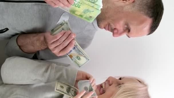 una mujer de mediana edad le pide a su marido dinero para comprar dólares y euros, el marido toma parte de ella, esposa, haciendo pucheros en los labios, esconde dinero en su pecho, ríe, sonríe, coquetea, el marido escondió dólares - Imágenes, Vídeo