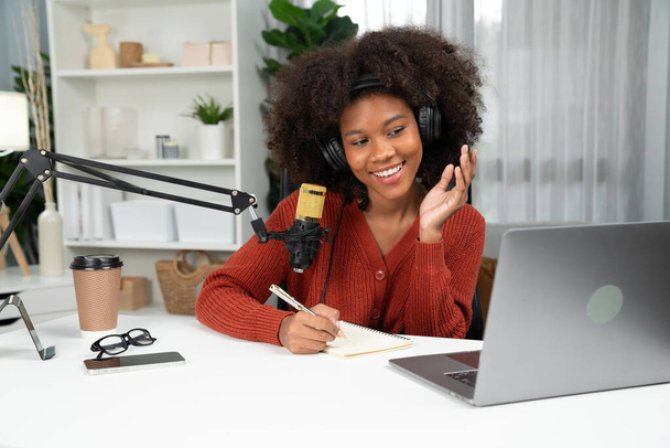 Prowadzący kanał pięknej afrykańskiej kobiety mówiącej w Internecie, uczącej influencera marketingu, ze słuchaczami w audycji lub online. Koncepcja każdego miejsca w pracy. Tastemaker. - Zdjęcie, obraz