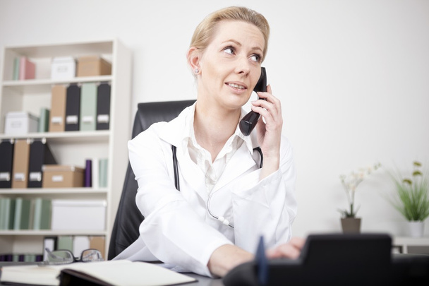 серйозна жінка лікар дзвонить через телефон
 - Фото, зображення