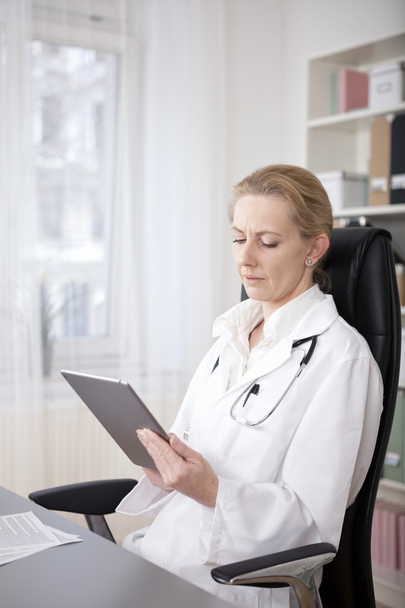Pensive Female Doctor Looking at Tablet Screen - Φωτογραφία, εικόνα