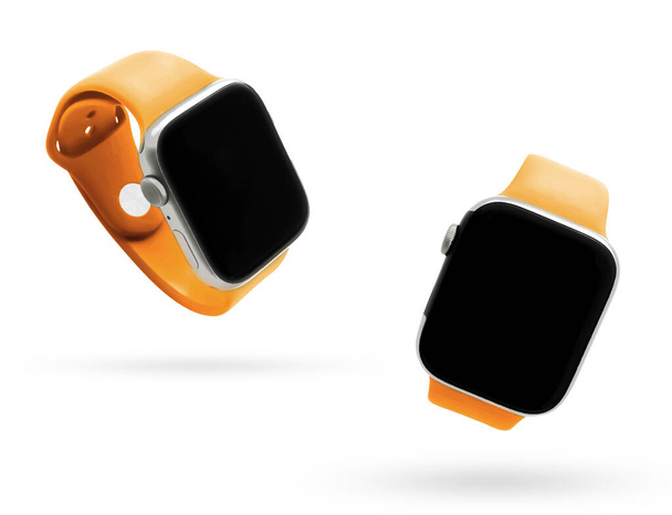 Smartwatch mit orangefarbenem Riemen schwebt in der Luft mit Schatten auf weißer Oberfläche, technisches Gadget-Hintergrundkonzept. - Foto, Bild