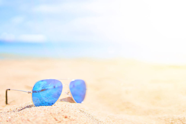 Okulary na piasku z oceanem i niebem na tle - Zdjęcie, obraz