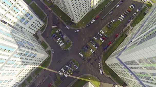 Grote parkeerplaats tussen gebouwen met veel auto's tijdens de dag - Video