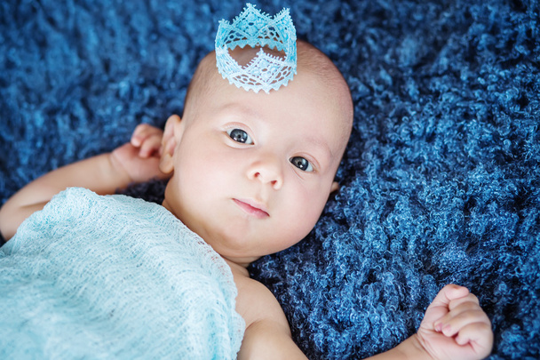 Πορτρέτο ενός νεογέννητου αγοριού με ένα μπλε στέμμα - Φωτογραφία, εικόνα